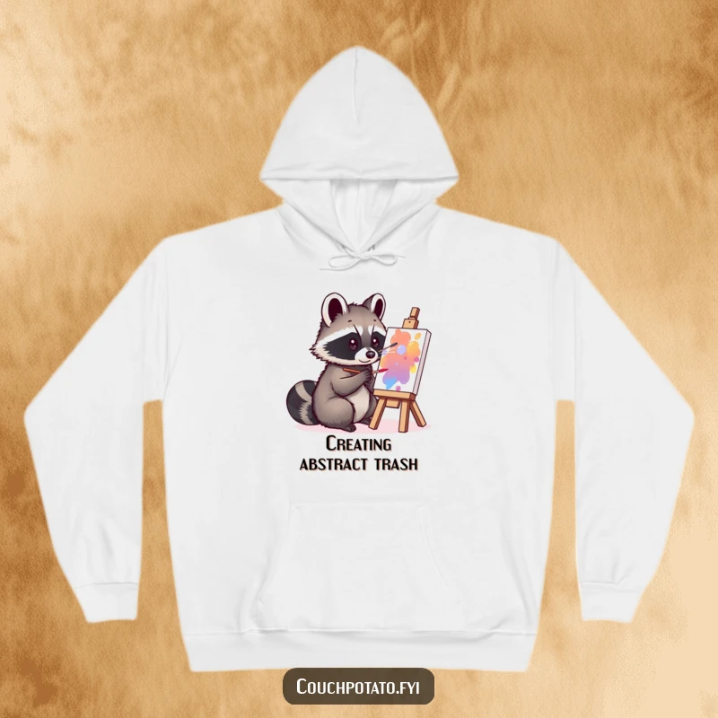 Funny curious raccoon engrossed in painting on a small canvas, featured on a warm hoodie, offering humorous artistic vibes.