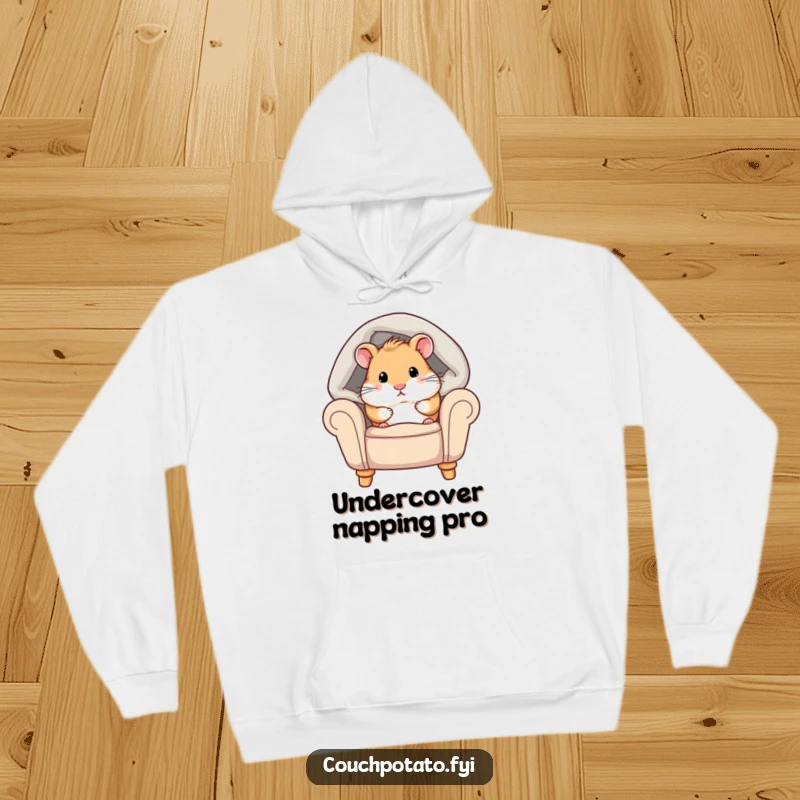 Funny hamster hoodie depicting a chubby hamster peeking from under a cozy blanket on an armchair, embodying warmth and ultimate comfort.