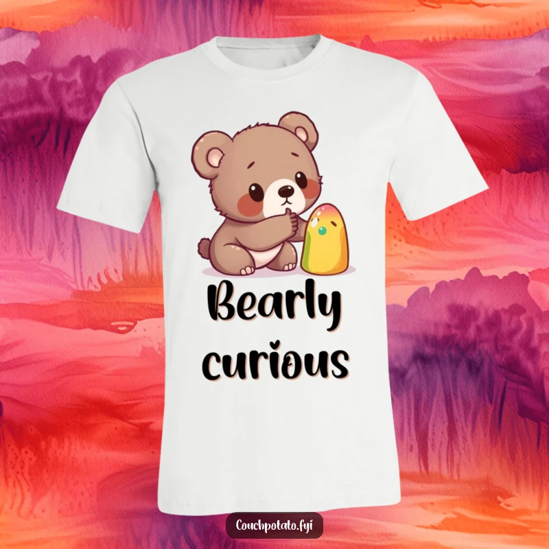 Funny T-shirt featuring a curious bear cub investigating a peculiar, vibrant object with a tentative poke, depicting a moment of discovery.