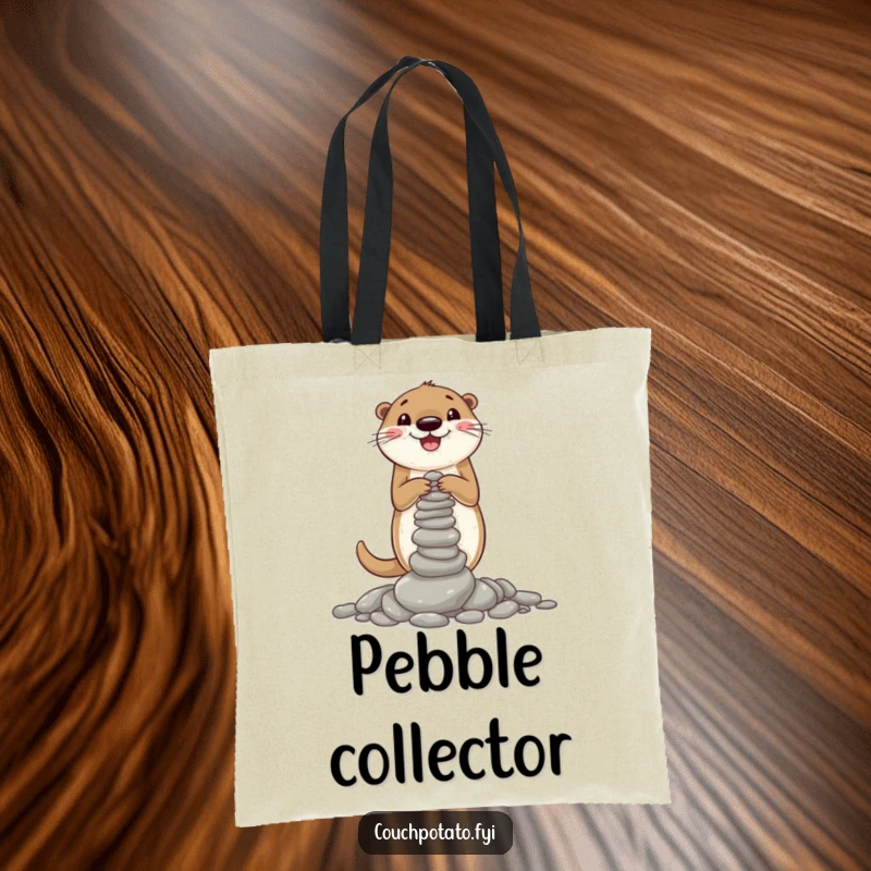 Funny tote bag illustrated with a cheerful otter intently building a small, wobbly stack of pebbles, a testament to its industrious nature.